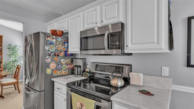 kitchen with white cabinetry, vaulted ceiling, and appliances with stainless steel finishes