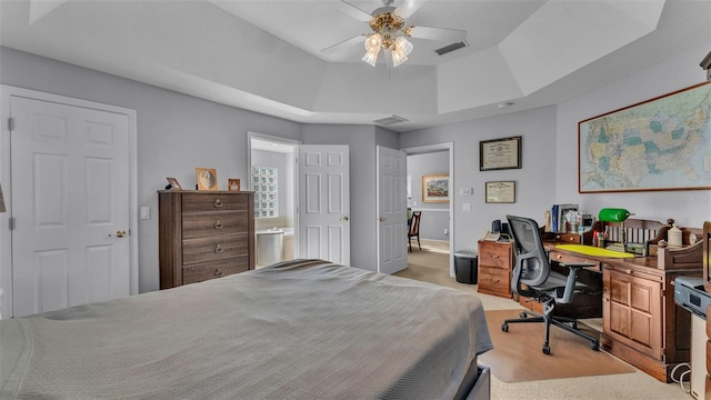 bedroom with light colored carpet, ceiling fan, and a tray ceiling