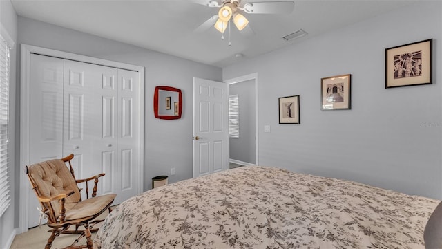 carpeted bedroom featuring ceiling fan and a closet