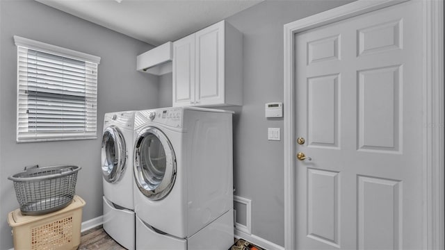 laundry room with cabinets, independent washer and dryer, and hardwood / wood-style floors