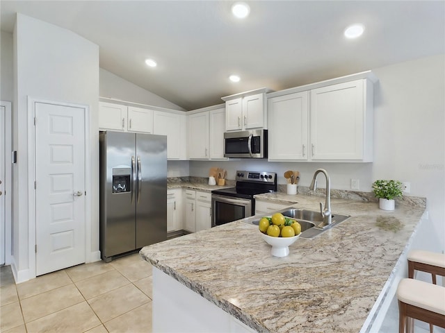 kitchen with a breakfast bar, white cabinetry, kitchen peninsula, and appliances with stainless steel finishes