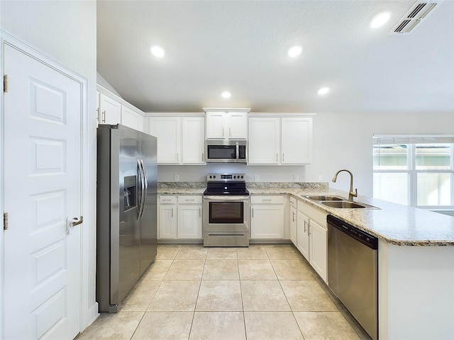 kitchen featuring sink, stainless steel appliances, white cabinets, kitchen peninsula, and light tile patterned flooring