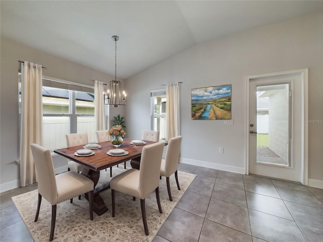 tiled dining area featuring vaulted ceiling and an inviting chandelier