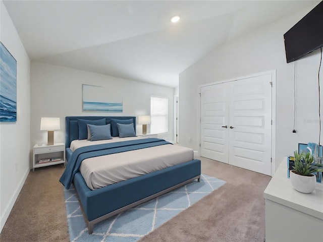 carpeted bedroom with vaulted ceiling and a closet