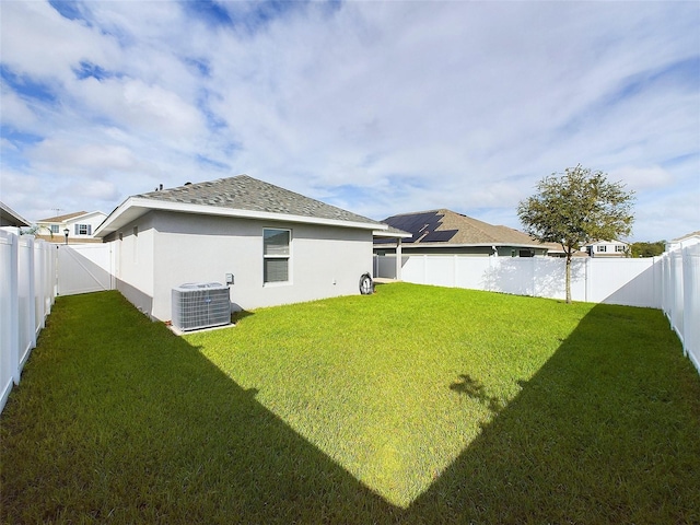 rear view of house with a yard and central air condition unit