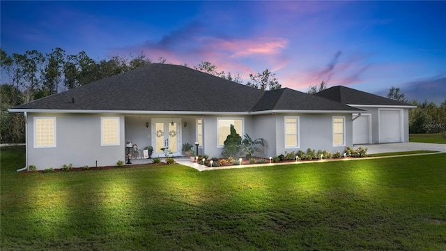 ranch-style home featuring a yard and a garage