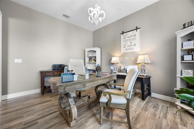 home office featuring wood-type flooring and a chandelier