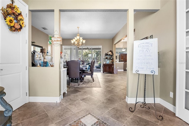 interior space featuring a textured ceiling and an inviting chandelier