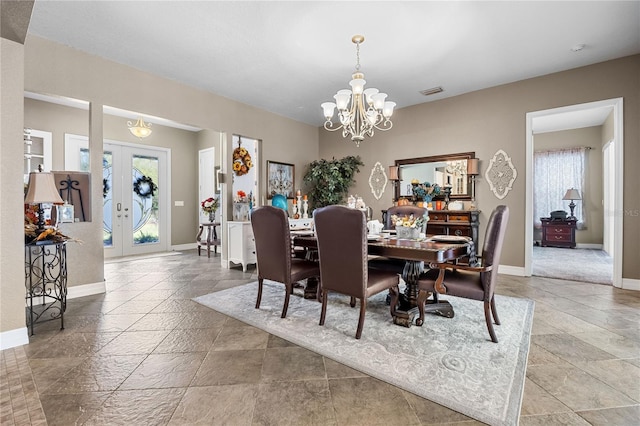 dining space featuring french doors and a notable chandelier