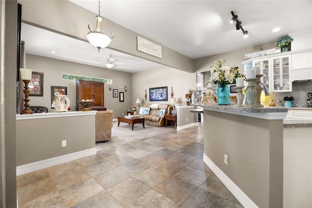 kitchen with pendant lighting, white cabinetry, and ceiling fan