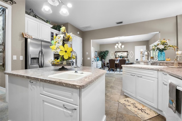 kitchen featuring stainless steel fridge with ice dispenser, a center island with sink, white cabinetry, and sink