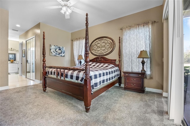 carpeted bedroom with ceiling fan, ensuite bath, and multiple windows