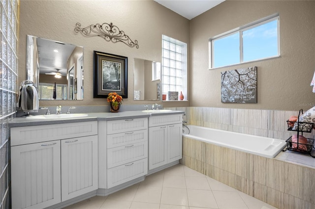 bathroom featuring vanity, tile patterned floors, ceiling fan, and tiled tub