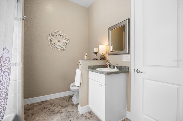 bathroom with walk in shower, vanity, and toilet