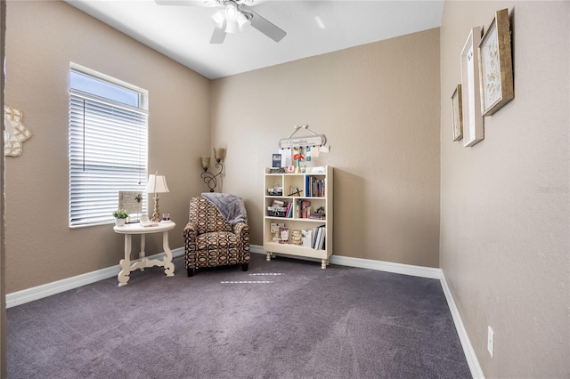 sitting room with dark carpet and ceiling fan