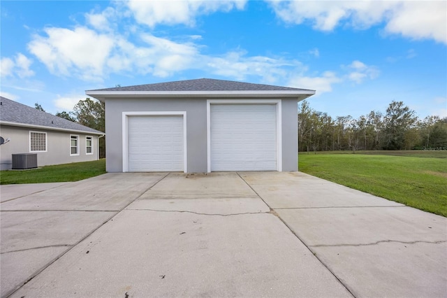 garage with a lawn and central AC unit