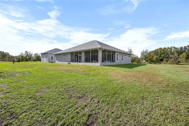 rear view of property with a lawn and a sunroom