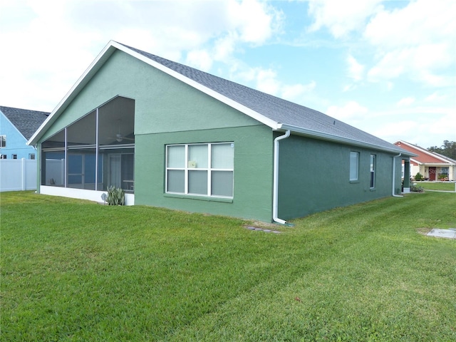 back of property with a lawn and a sunroom