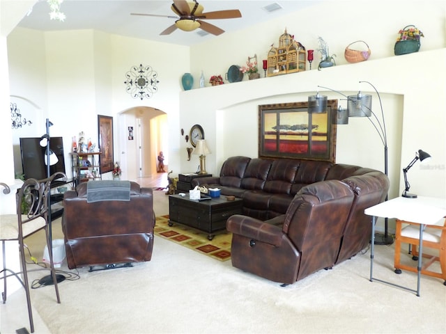 living room featuring a high ceiling, carpet floors, and ceiling fan