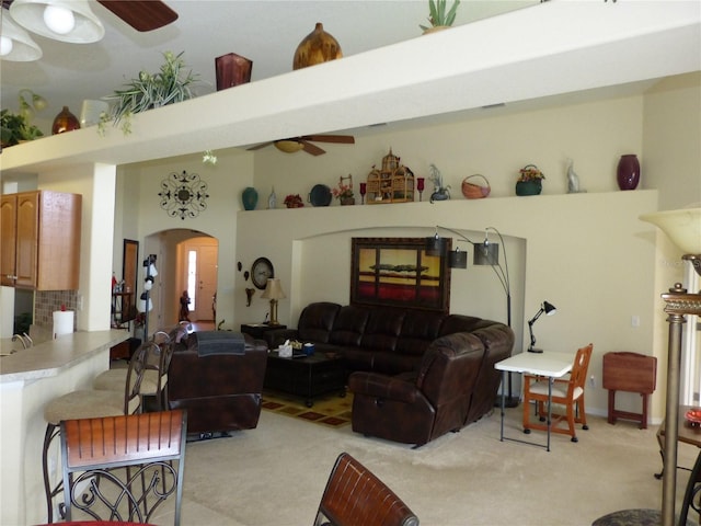 carpeted living room featuring ceiling fan and a high ceiling