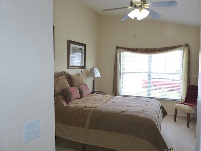 carpeted bedroom with ceiling fan and vaulted ceiling