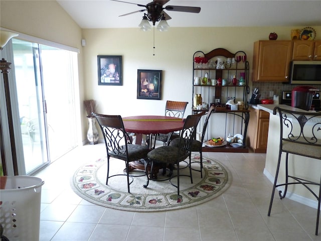 tiled dining room with vaulted ceiling and ceiling fan