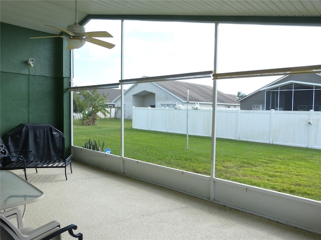 unfurnished sunroom with ceiling fan and vaulted ceiling