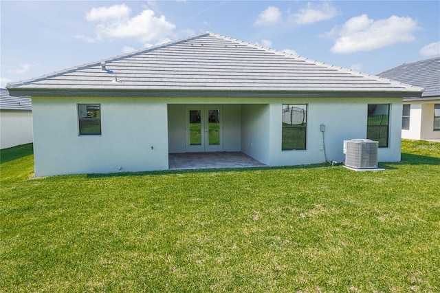 back of house with central air condition unit, a patio area, a yard, and french doors