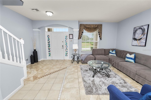 living room featuring ornate columns and light tile patterned flooring