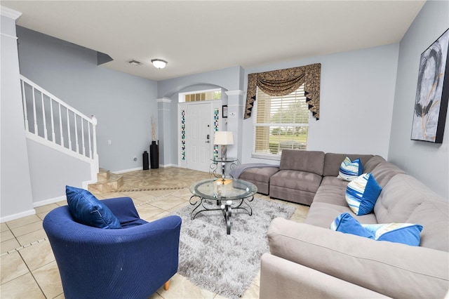 living room featuring decorative columns and light tile patterned flooring