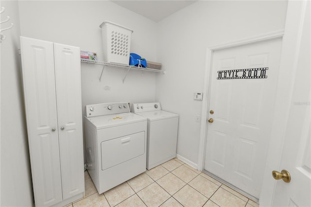 clothes washing area with light tile patterned flooring and independent washer and dryer