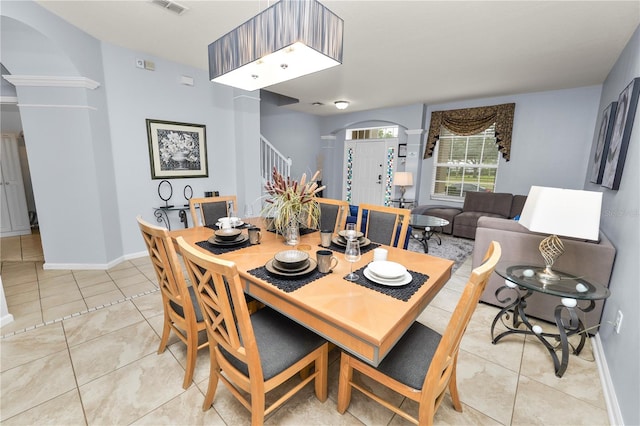 dining room with light tile patterned floors and decorative columns