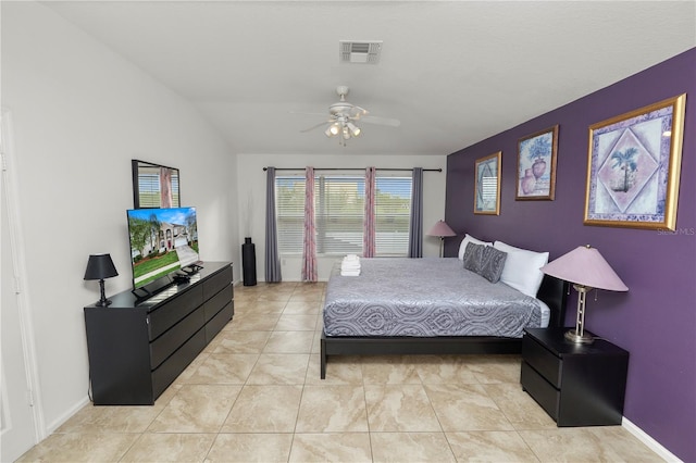 bedroom featuring ceiling fan, lofted ceiling, and light tile patterned flooring