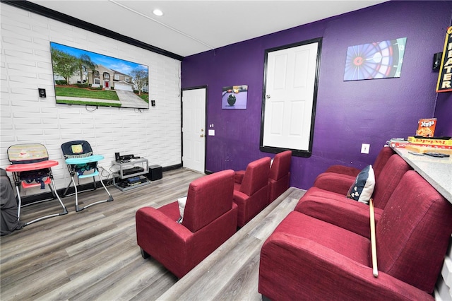 cinema room with hardwood / wood-style flooring and brick wall