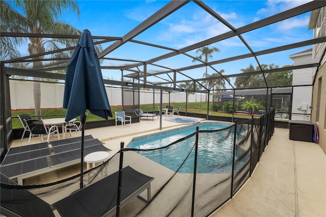 view of swimming pool featuring glass enclosure and a patio