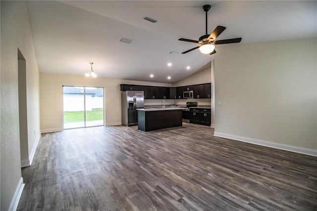 kitchen featuring a kitchen island with sink, dark wood-style flooring, a sink, open floor plan, and appliances with stainless steel finishes