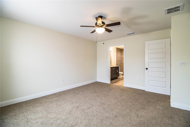 unfurnished bedroom with baseboards, ensuite bathroom, visible vents, and light colored carpet