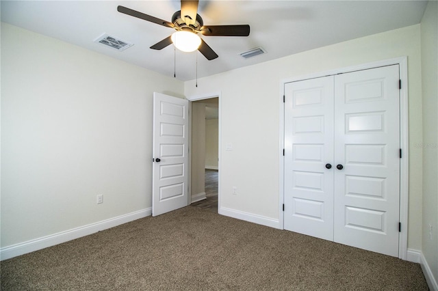 unfurnished bedroom featuring baseboards, visible vents, dark carpet, and a closet