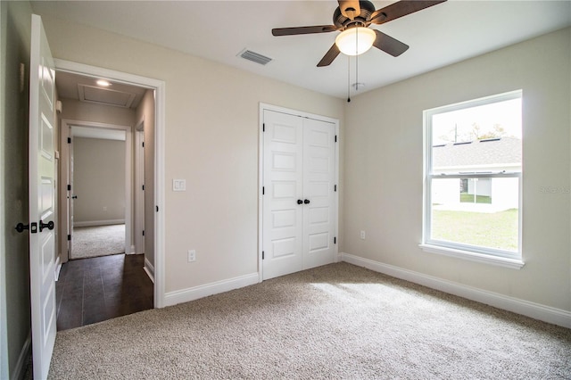 unfurnished bedroom featuring a closet, carpet flooring, visible vents, and baseboards