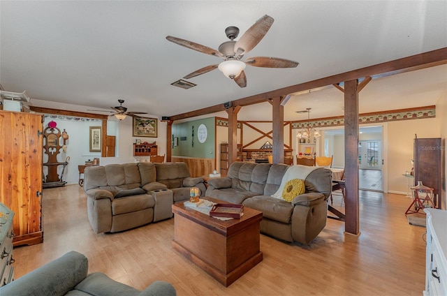 living room featuring ceiling fan with notable chandelier and light hardwood / wood-style floors