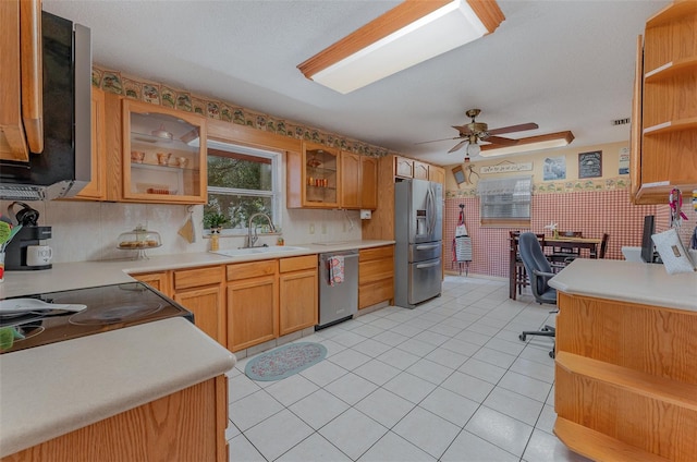 kitchen with ceiling fan, sink, light tile patterned flooring, and stainless steel appliances