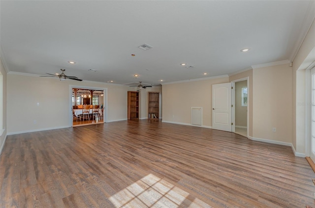 unfurnished living room featuring wood-type flooring, plenty of natural light, ornamental molding, and ceiling fan