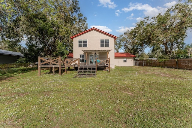 back of property featuring a lawn and a wooden deck