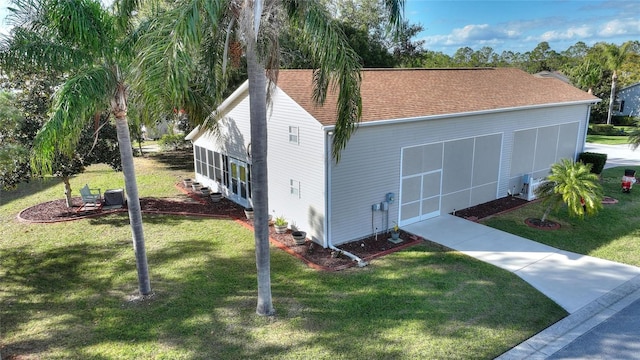 view of side of property with a yard and a sunroom