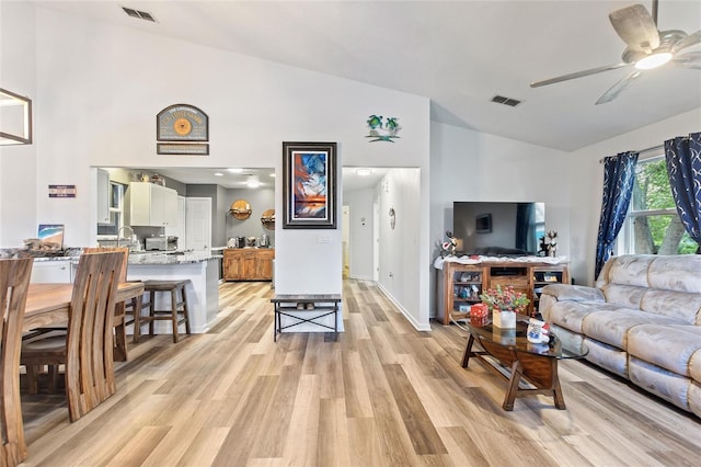 living room with high vaulted ceiling, light hardwood / wood-style flooring, and ceiling fan