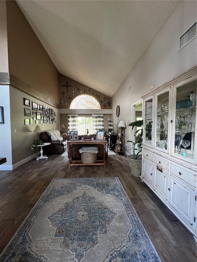 interior space with high vaulted ceiling and dark wood-type flooring