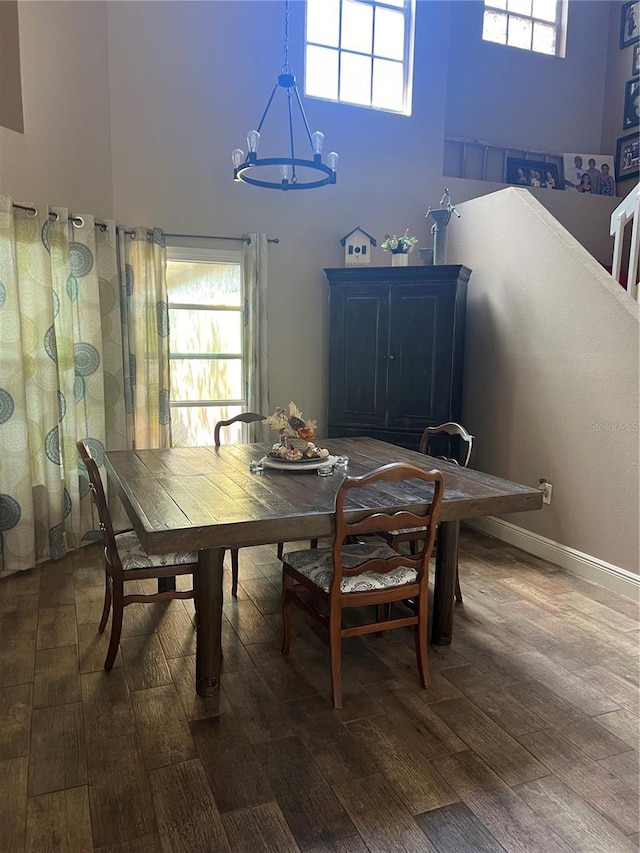 dining room with a notable chandelier, dark hardwood / wood-style flooring, and a high ceiling