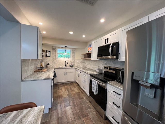 kitchen featuring white cabinetry, sink, stainless steel appliances, light stone counters, and dark hardwood / wood-style floors