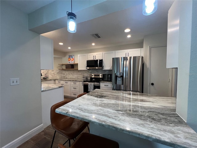 737 Butternut Pl, Lakeland, FL 33813 - kitchen with appliances with stainless steel finishes, backsplash, open shelves, white cabinetry, and decorative light fixtures