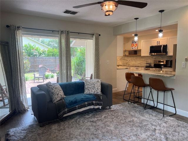 living room featuring dark hardwood / wood-style flooring and ceiling fan